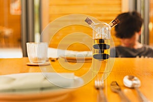 A glass bottle with olive oil and balsamic vinegar on dinner table.