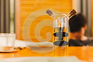 A glass bottle with olive oil and balsamic vinegar on dinner table.