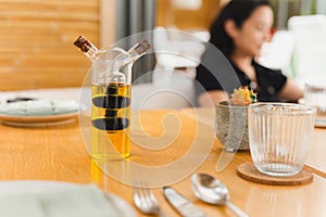 A glass bottle with olive oil and balsamic vinegar on dinner table.