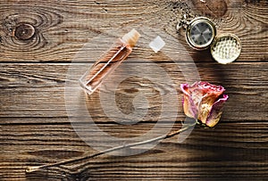 A glass bottle with perfume, dry rose, vintage pocket watch