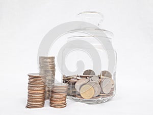 Glass bottle piggy bank with coins pile, Saving money for future plan and retirement fund concept