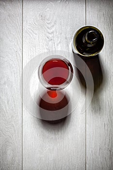 Glass and bottle of red wine with cork on table