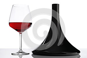 Glass and bottle of red wine decanter on white