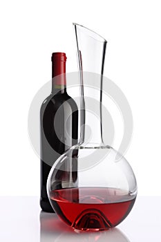 Glass and bottle of red wine decanter on white