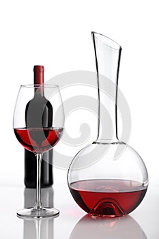 Glass and bottle of red wine decanter on white