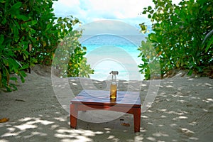 Glass bottle of refreshing bewerage on the table with ocean view on background photo