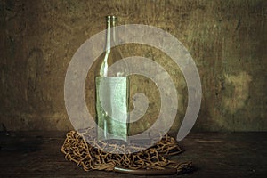 Glass bottle of Russian vodka in a bag net on a wooden table photo