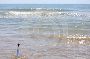 glass bottle with secret message inside by the sea