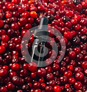 Glass bottle with serum or essential and fresh cranberries