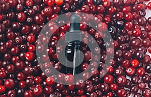 Glass bottle with serum or essential and fresh cranberries