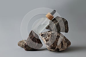 Glass bottle and stones on grey background