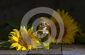 glass Bottle of sunflower oil with flower. wooden table. black background still life Natural Homemade rustic. beautiful