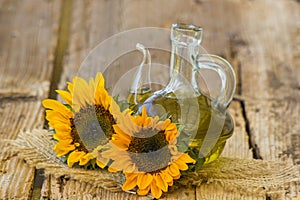 Glass bottle with sunflower oil and sunflowers