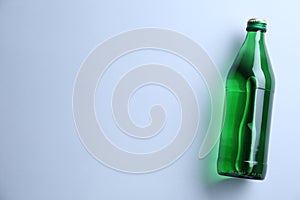 Glass bottle with water on white background, top view. Space for text