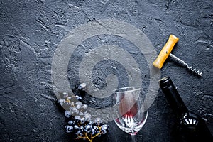 Glass bottle of wine with grapes on stone top view mock up