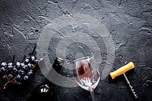 Glass bottle of wine with grapes on stone top view mock up