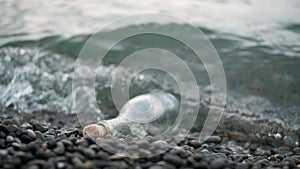 Glass bottle with wooden cork on sea or ocean. concept of note for posterity thrown into water. vintage glass bottle