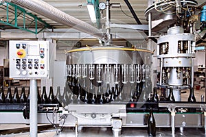 Glass bottles on the automatic conveyor line at the champagne or wine factory. Plant for bottling alcoholic beverages.