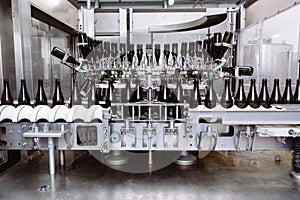 Glass bottles on the automatic conveyor line at the champagne or wine factory. Plant for bottling alcoholic beverages.