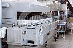 Glass bottles on the automatic conveyor line at the champagne or wine factory. Plant for bottling alcoholic beverages.