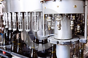 Glass bottles on the automatic conveyor line at the champagne or wine factory. Plant for bottling alcoholic beverages.