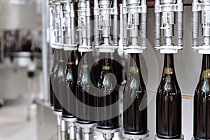 Glass bottles on the automatic conveyor line at the champagne or wine factory. Plant for bottling alcoholic beverages.