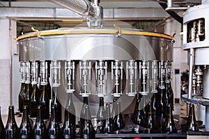 Glass bottles on the automatic conveyor line at the champagne or wine factory. Plant for bottling alcoholic beverages.