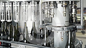 Glass bottles on the automatic conveyor line at the champagne or wine factory. Plant for bottling alcoholic beverages.