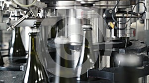 Glass bottles on the automatic conveyor line at the champagne or wine factory. Plant for bottling alcoholic beverages.