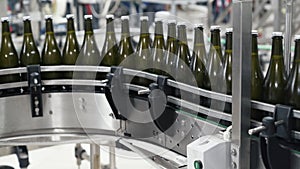 Glass bottles on the automatic conveyor line at the champagne or wine factory. Plant for bottling alcoholic beverages.