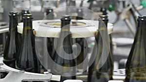 Glass bottles on the automatic conveyor line at the champagne or wine factory. Plant for bottling alcoholic beverages.