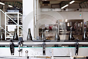 Glass bottles on the automatic conveyor line at the champagne or wine factory. Plant for bottling alcoholic beverages.