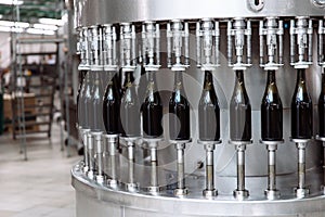 Glass bottles on the automatic conveyor line at the champagne or wine factory. Plant for bottling alcoholic beverages.