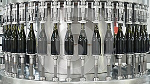 Glass bottles on the automatic conveyor line at the champagne or wine factory. Plant for bottling alcoholic beverages.