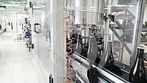 Glass bottles on the automatic conveyor line at the champagne or wine factory. Plant for bottling alcoholic beverages.