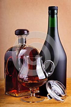 Glass and bottles of brandy photo