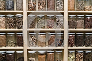 Glass bottles with colorful spices on the shelfs