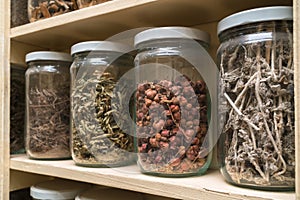 Glass bottles with colorful spices on the shelfs