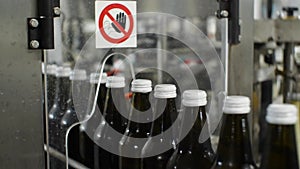 Glass bottles on the conveyor line in the workshop for the production of mineral water and soft drinks