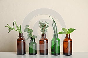 Glass bottles of different essential oils with plants