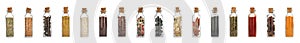 Glass bottles with different spices and herbs on white background.