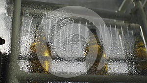 Glass bottles pass through the rinsing unit. Shop for the production of mineral water and soft drinks