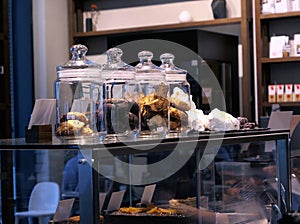 Glass bottles with sweet cookies in evening cafe