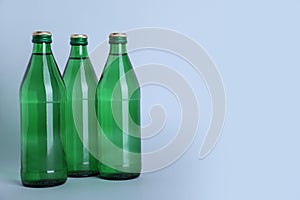 Glass bottles with water on white background  space for text