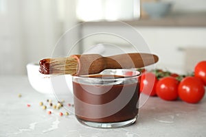 Glass bowl of barbecue sauce with basting brush