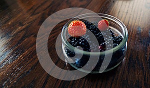 Glass bowl with blackberries and strawberries.