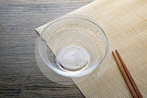 Glass bowl and chopsticks on wooden table