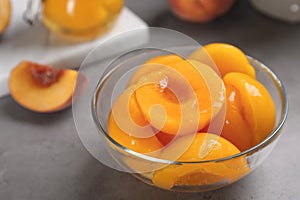 Glass bowl with conserved peach halves photo