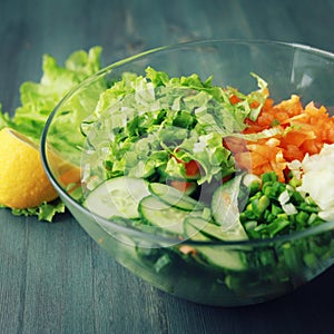 Glass bowl with cutted vegetables for a salad.