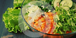Glass bowl with cutted vegetables for a salad.